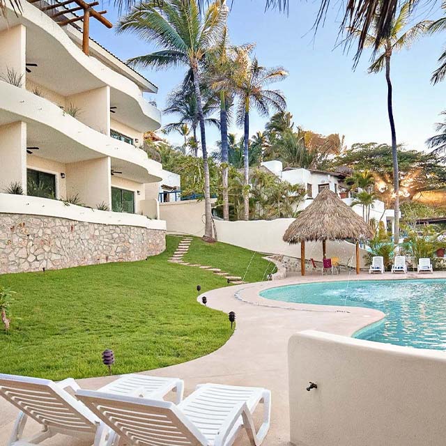 a pool with palm trees and a building