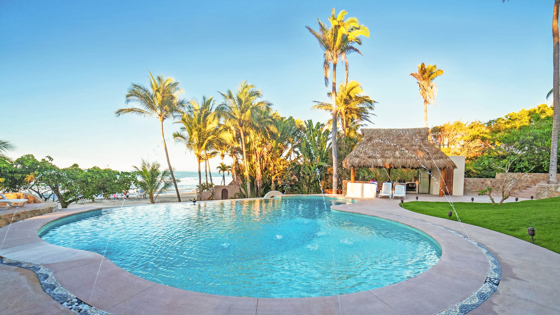 a pool with palm trees and a hut