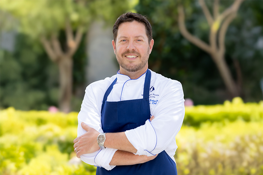 a chef standing with arms crossed