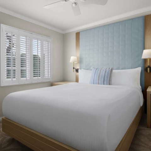 a bed with a white sheet and a blue headboard