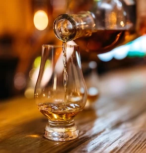 a person pouring a glass of alcohol