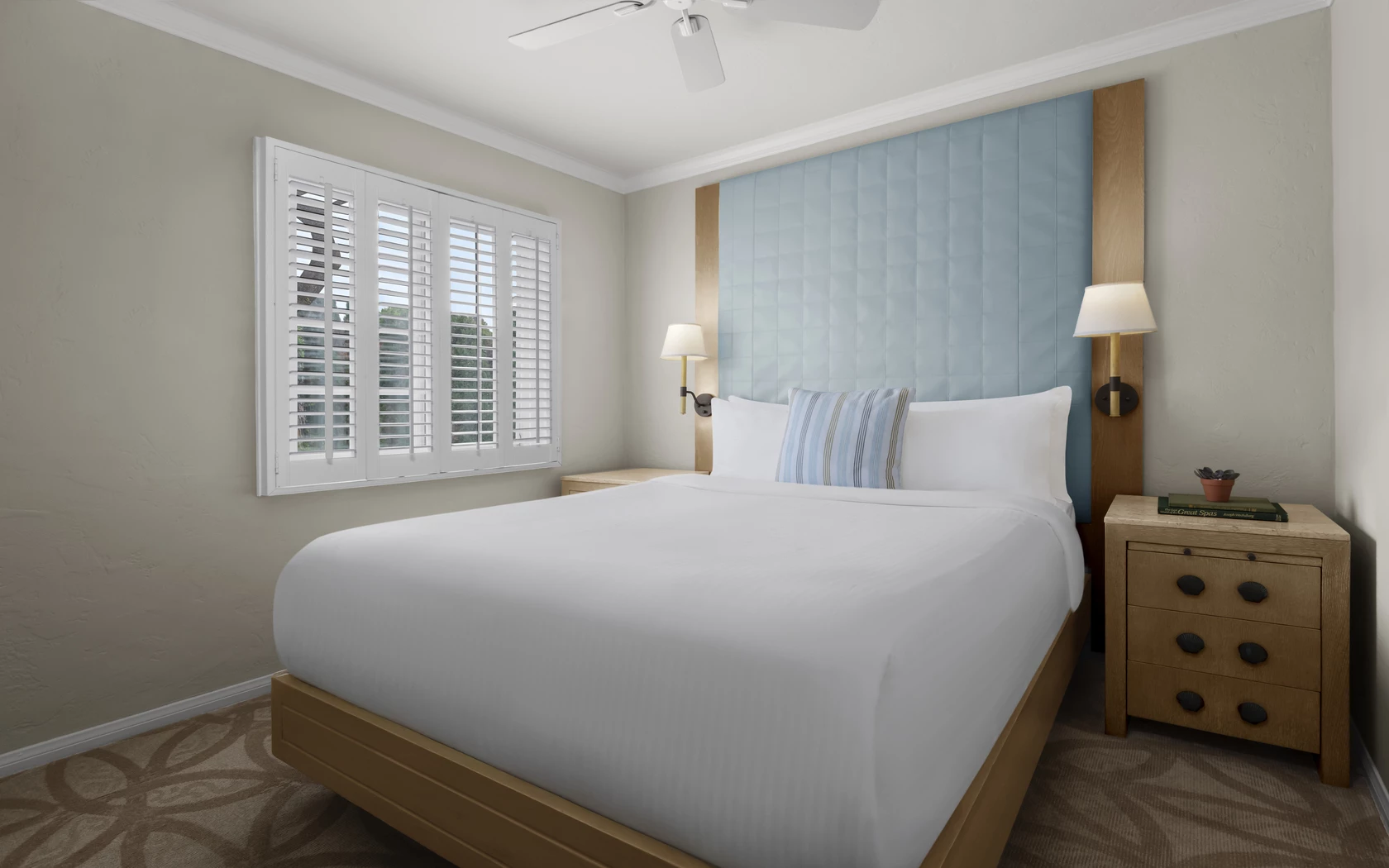 a bed with a white sheet and a blue headboard
