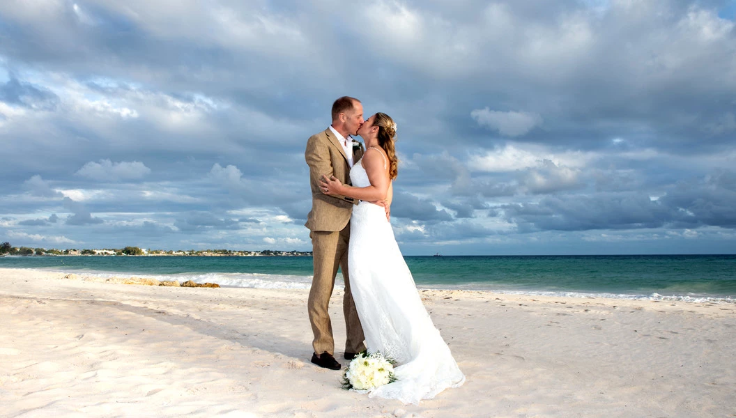 Bride and groom kissing on the beach
