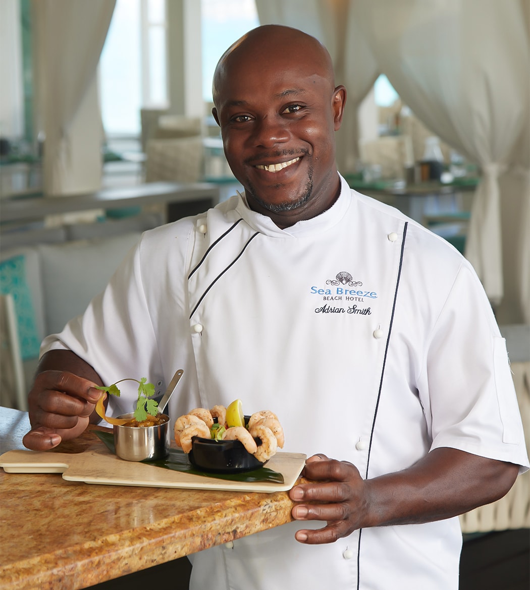 a man in a chef's uniform holding a plate of food