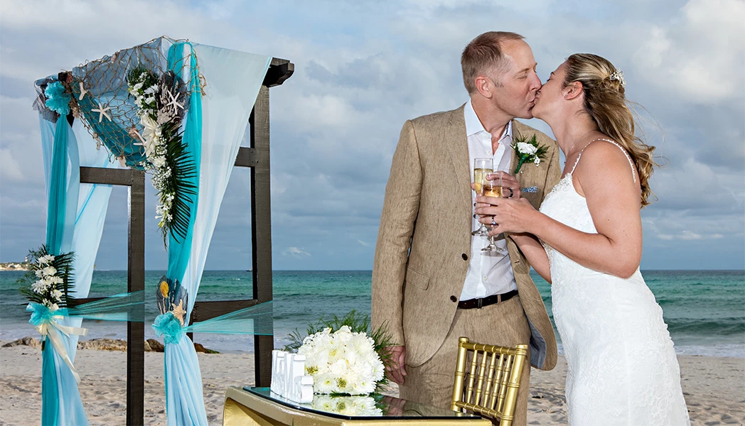 bride and groom kissing next to wedding alter