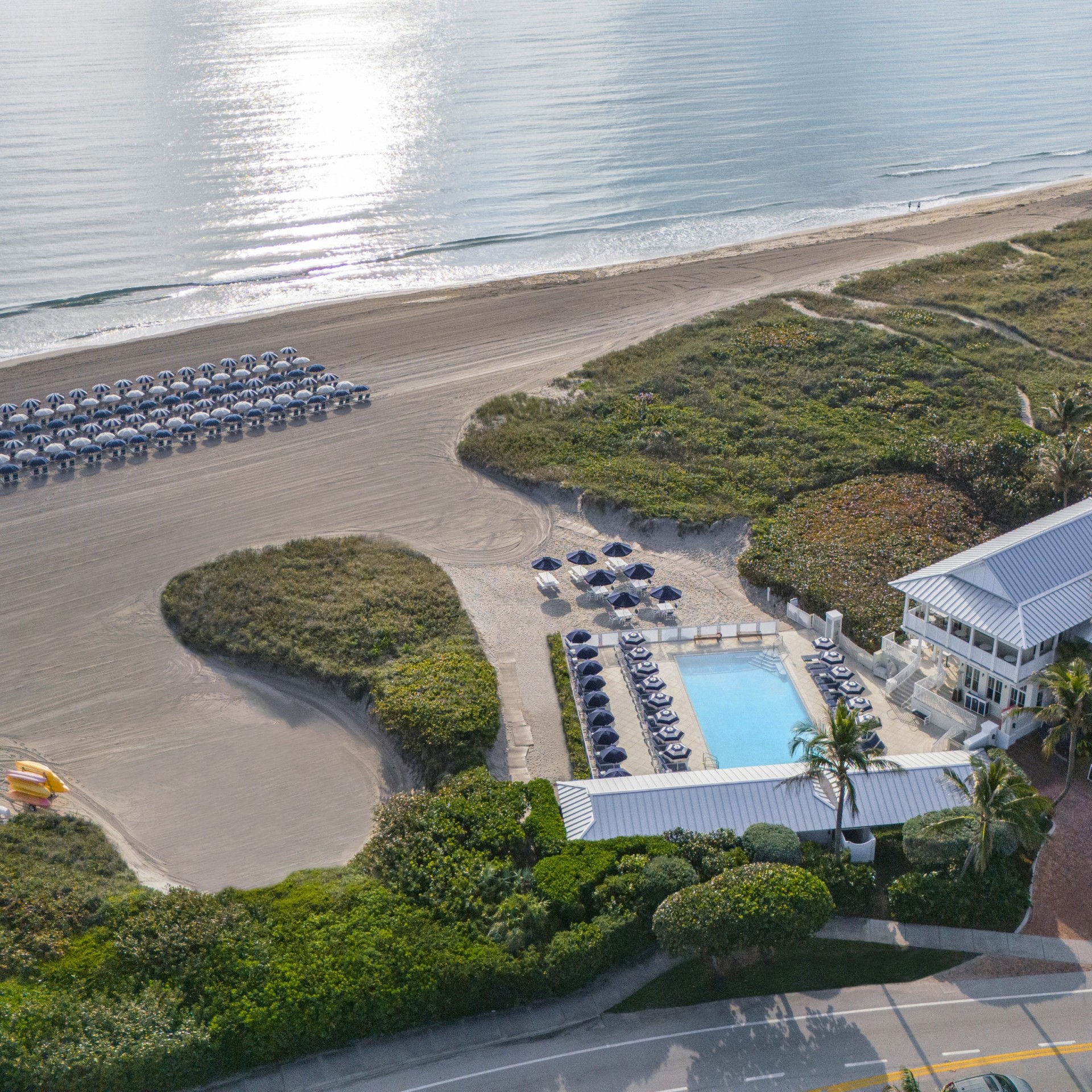 a beach with a pool and chairs