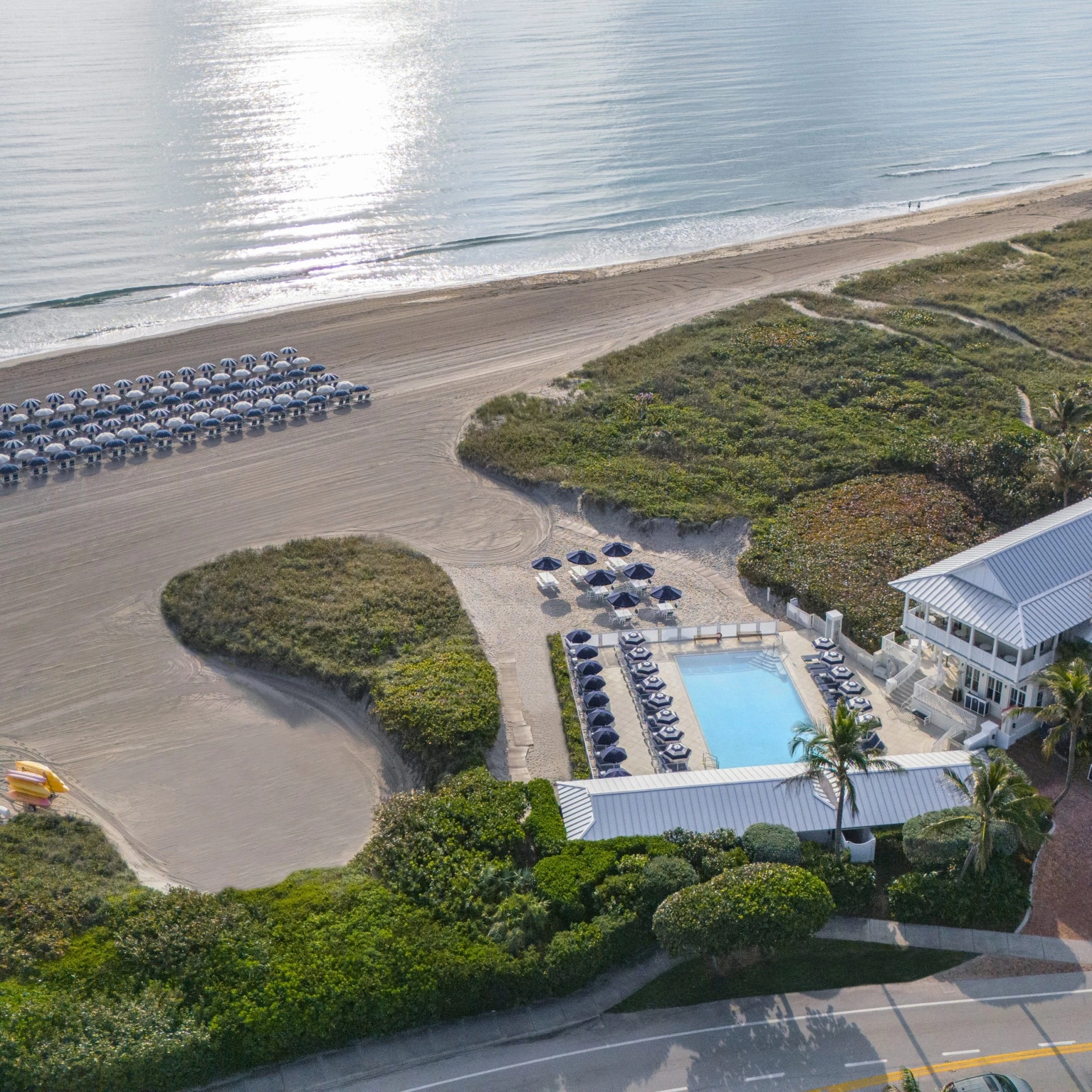 a beach with a pool and chairs