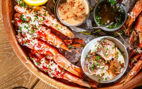 a bowl of seafood with different sauces