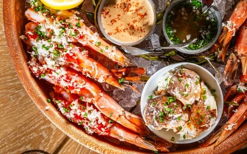 a bowl of seafood with different sauces