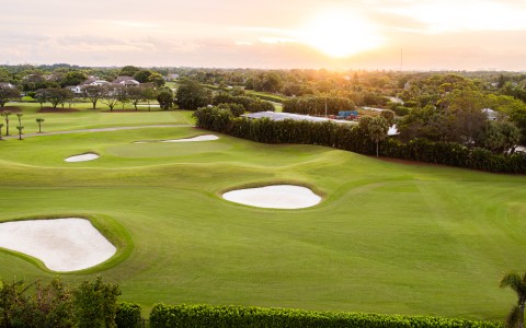 a golf course with a sunset