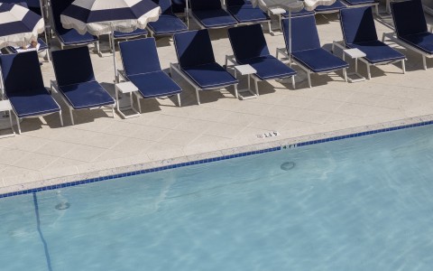 a pool with chairs and umbrellas