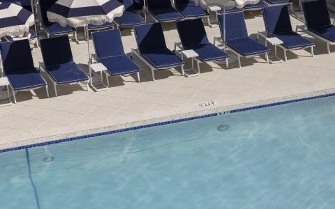 a pool with chairs and umbrellas