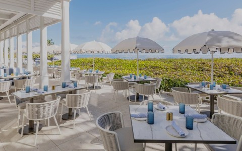 a table and chairs with umbrellas on a patio