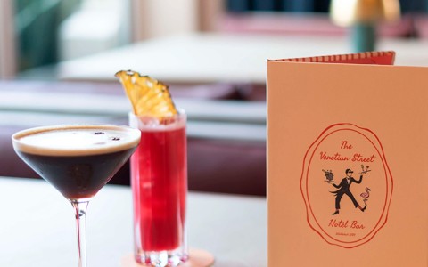 a cocktail and a menu on a table