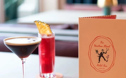 a cocktail and a menu on a table