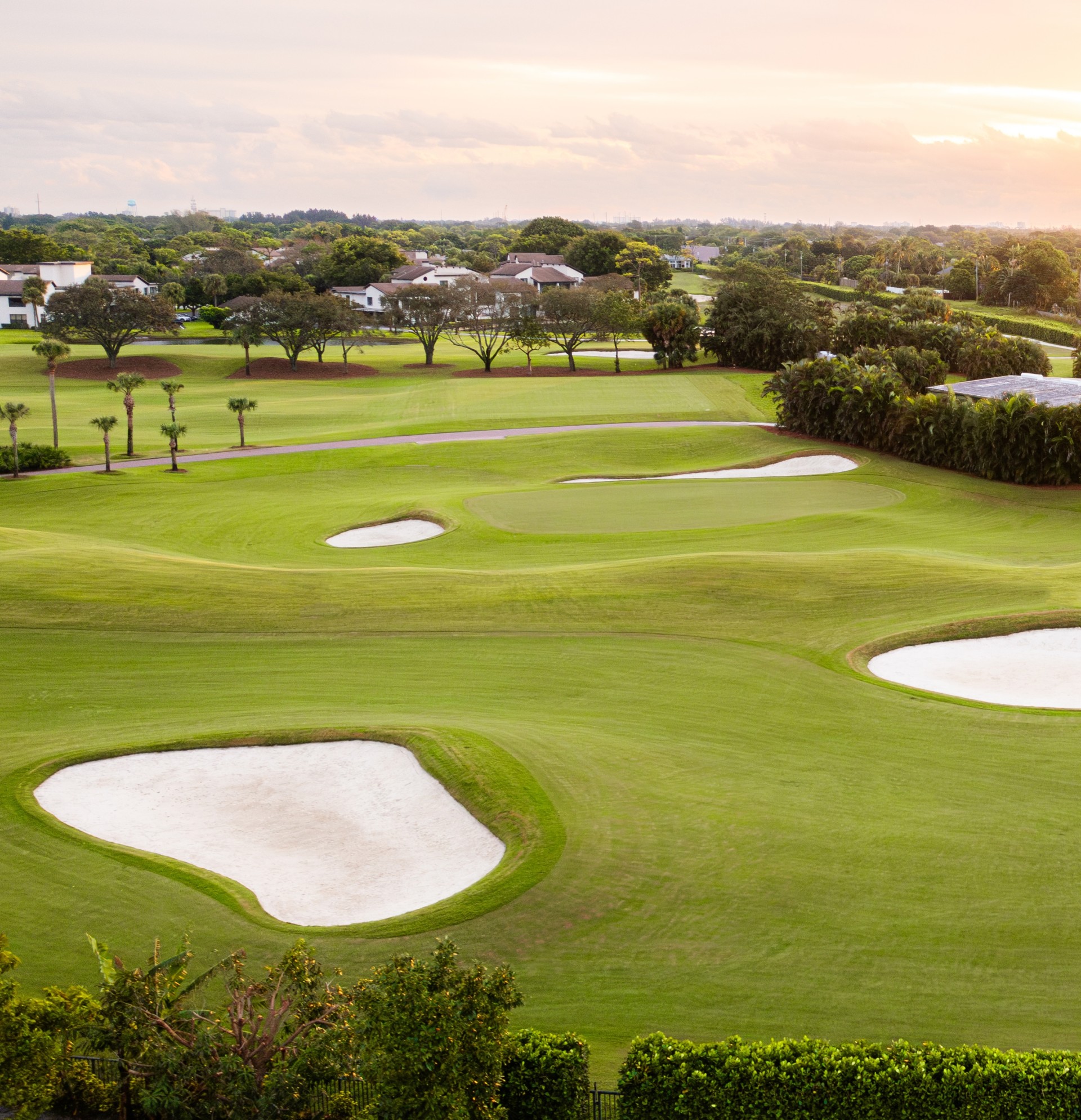 a golf course with a group of houses and a road