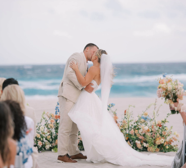 a man and woman kissing on a beach