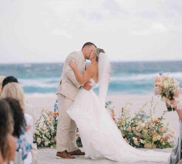 a man and woman kissing on a beach