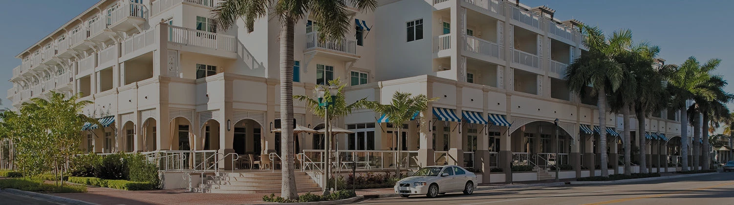 corner exterior view of hotel with a parked car
