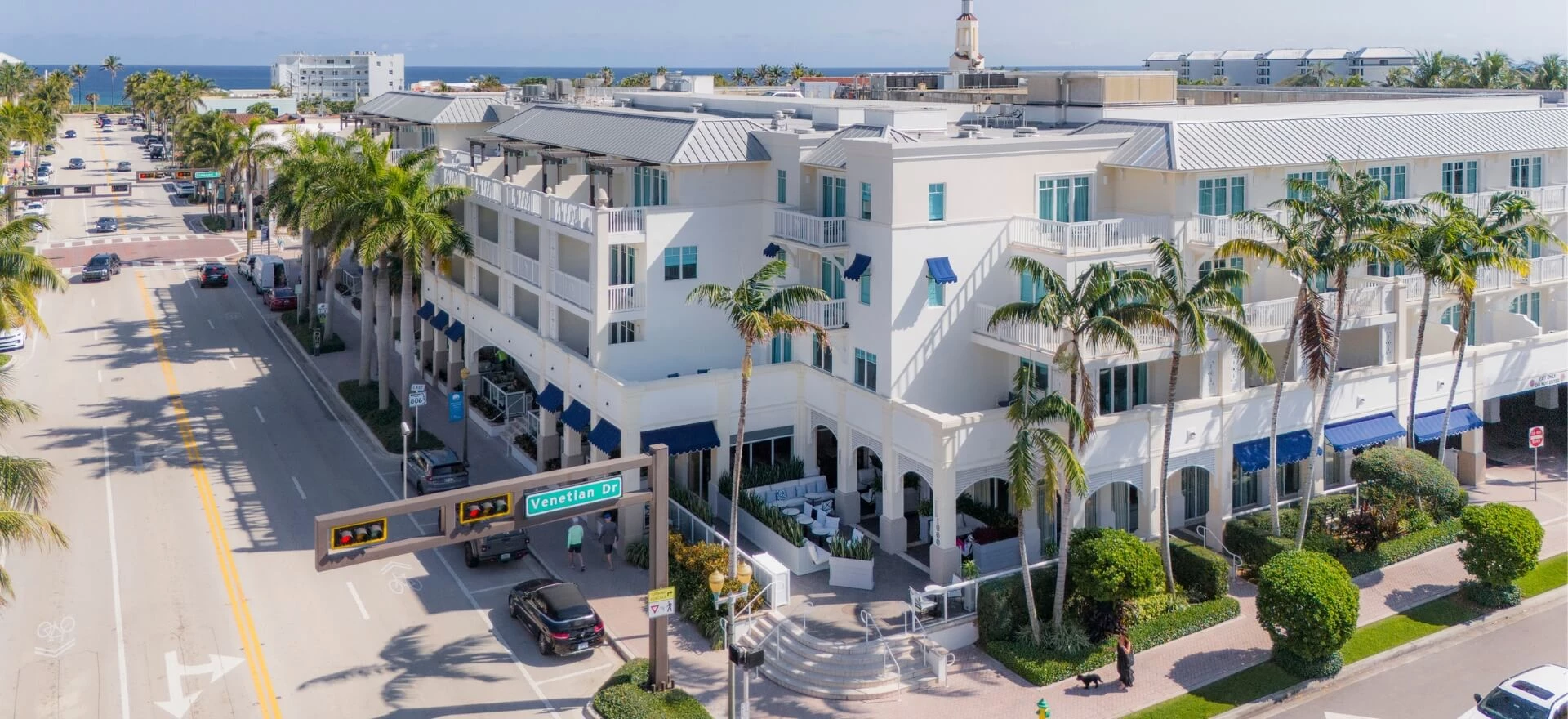 a building with palm trees and a street sign