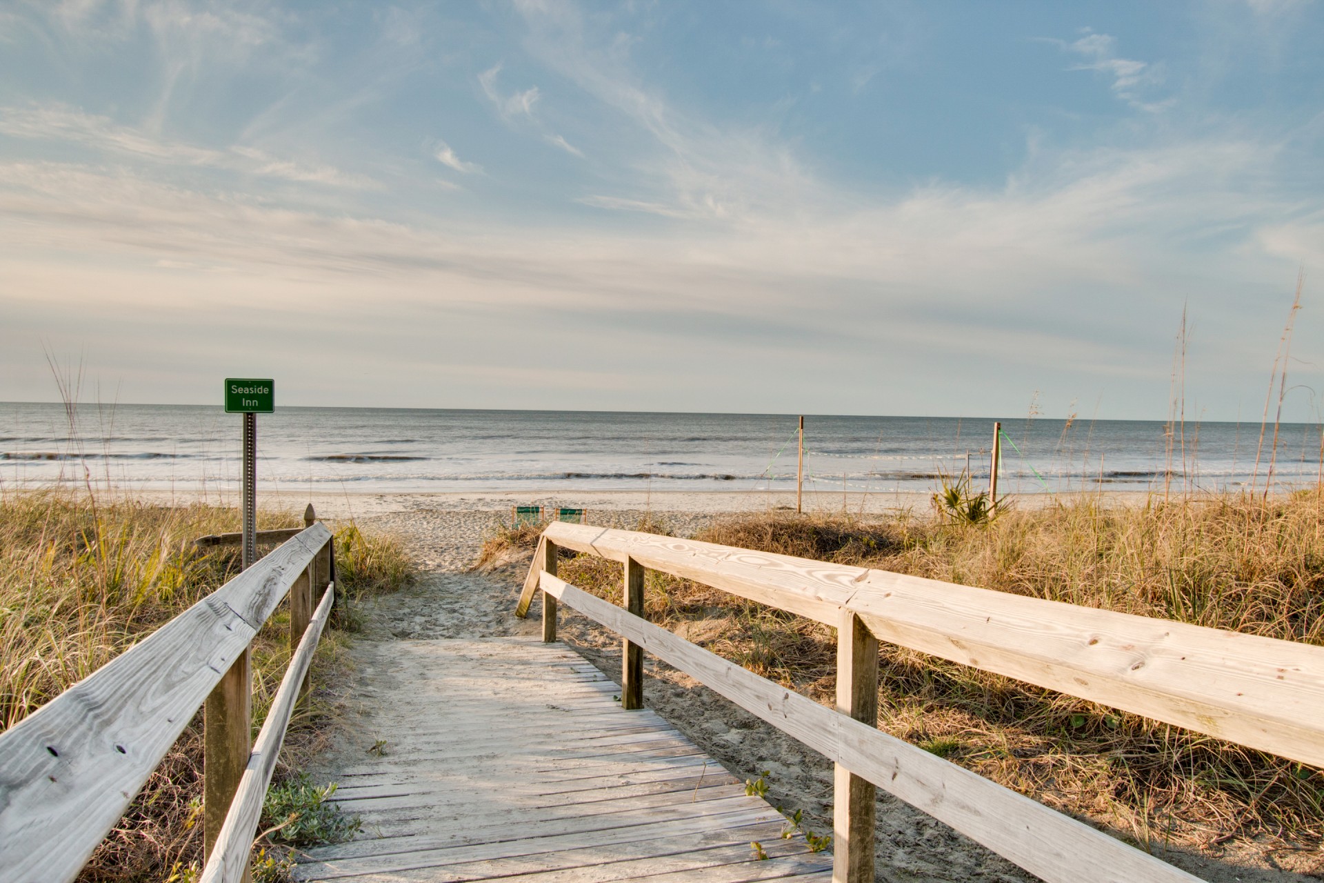 a wooden walkway leading to a beach