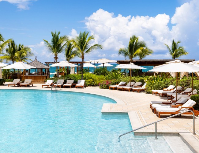 a pool with lounge chairs and umbrellas