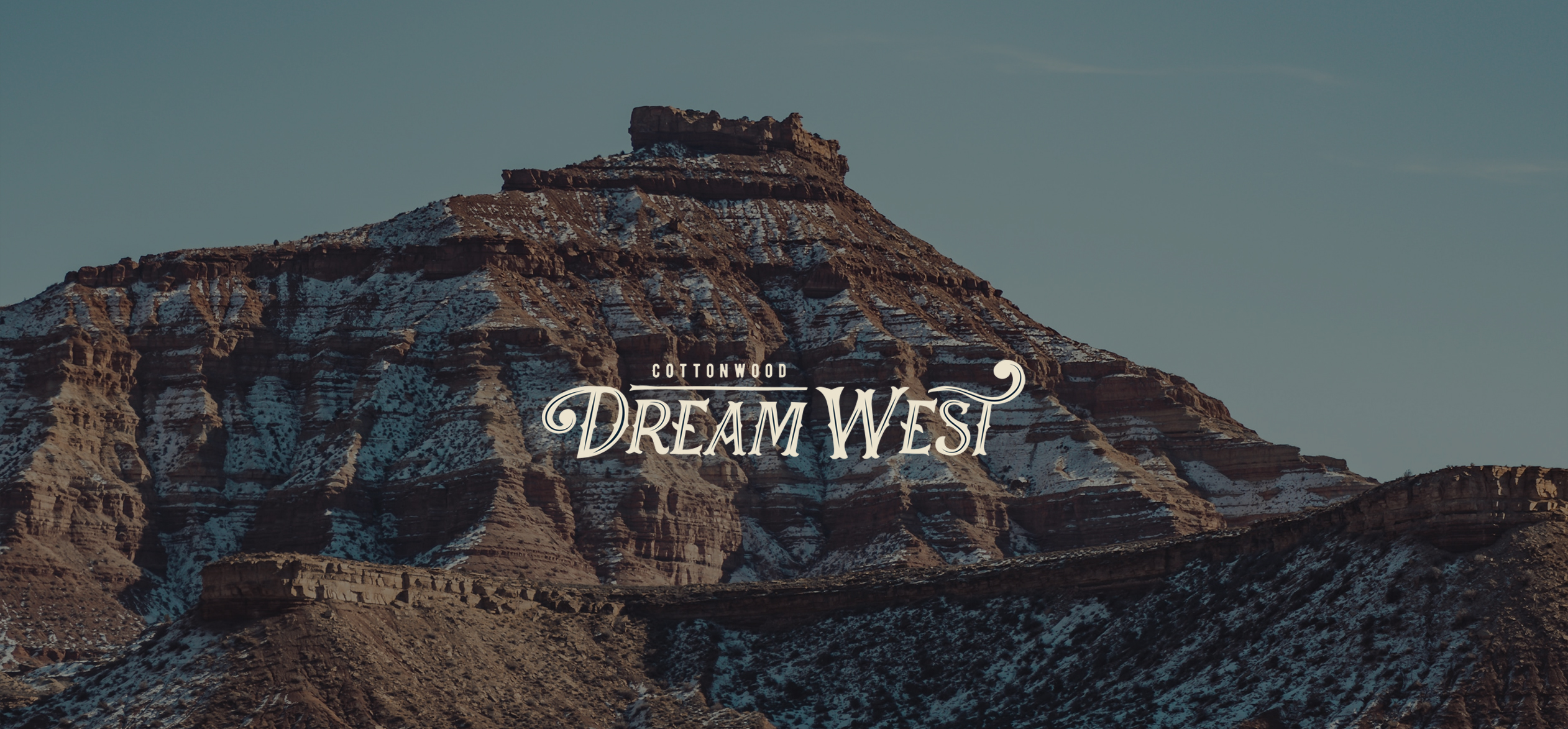 a mountain with snow on it with text "Dream West" overlaid