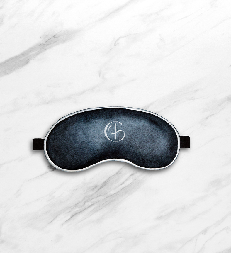 a black eye mask with the grayson hotel logo on it on a marble surface