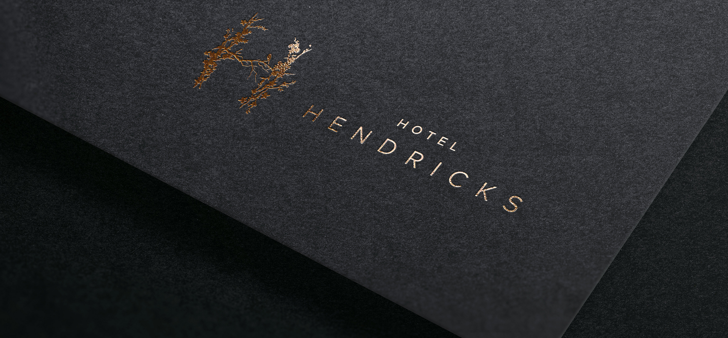 a black and gold logo that says "Hotel Hendricks"