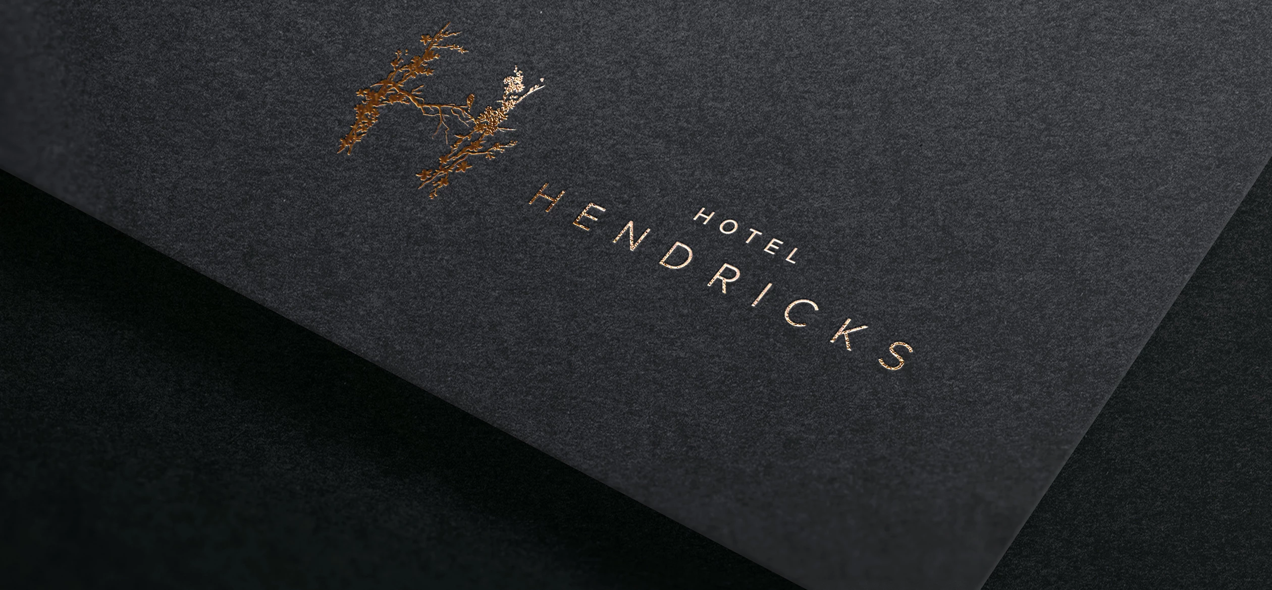 a black and gold logo that says "Hotel Hendricks"