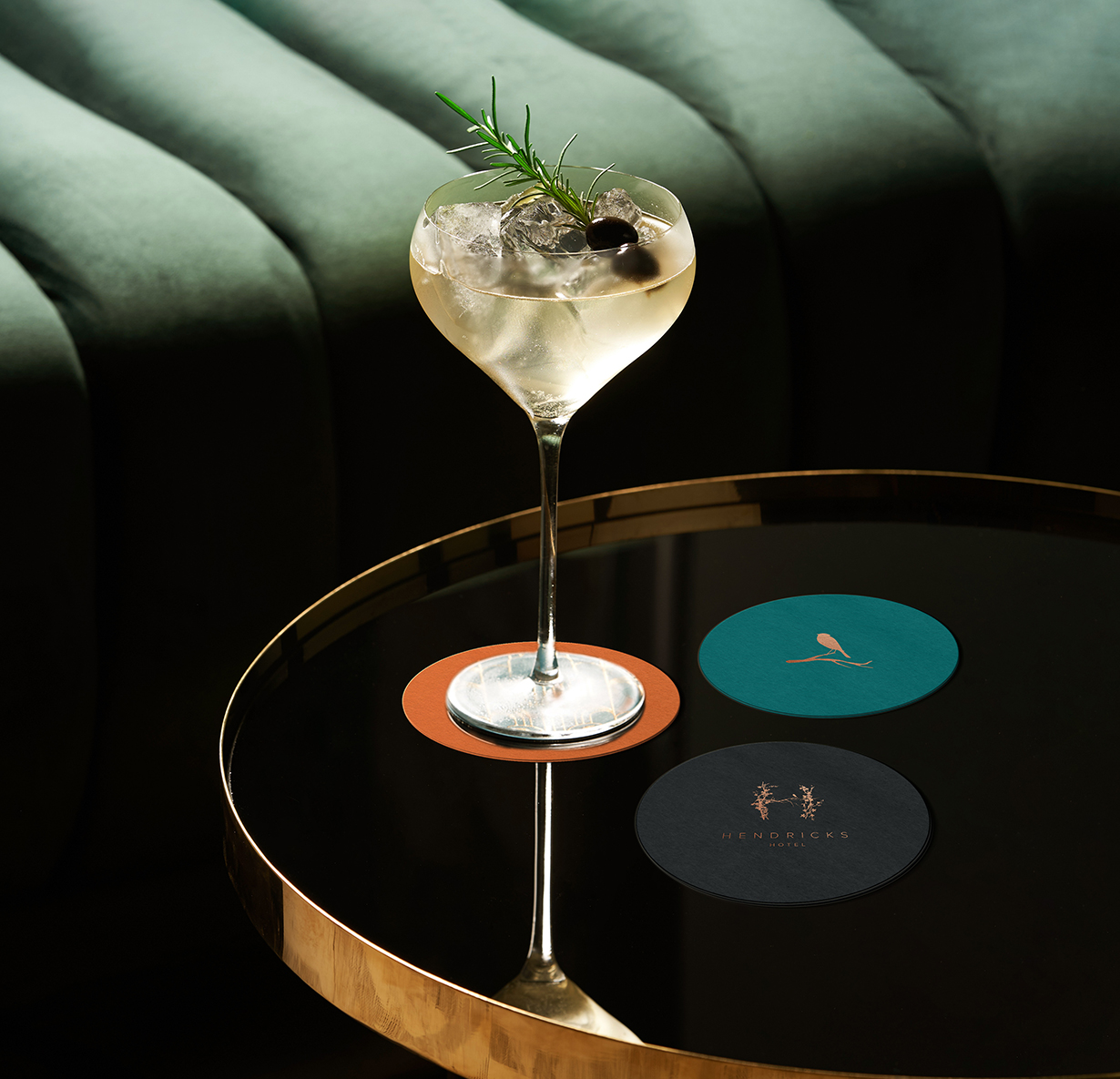 a glass of drink on a table with branded coasters