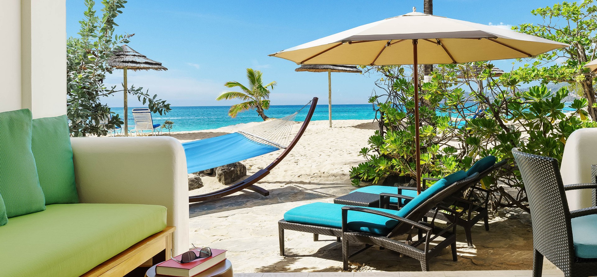 beach with sun loungers, an umbrella and a hammock