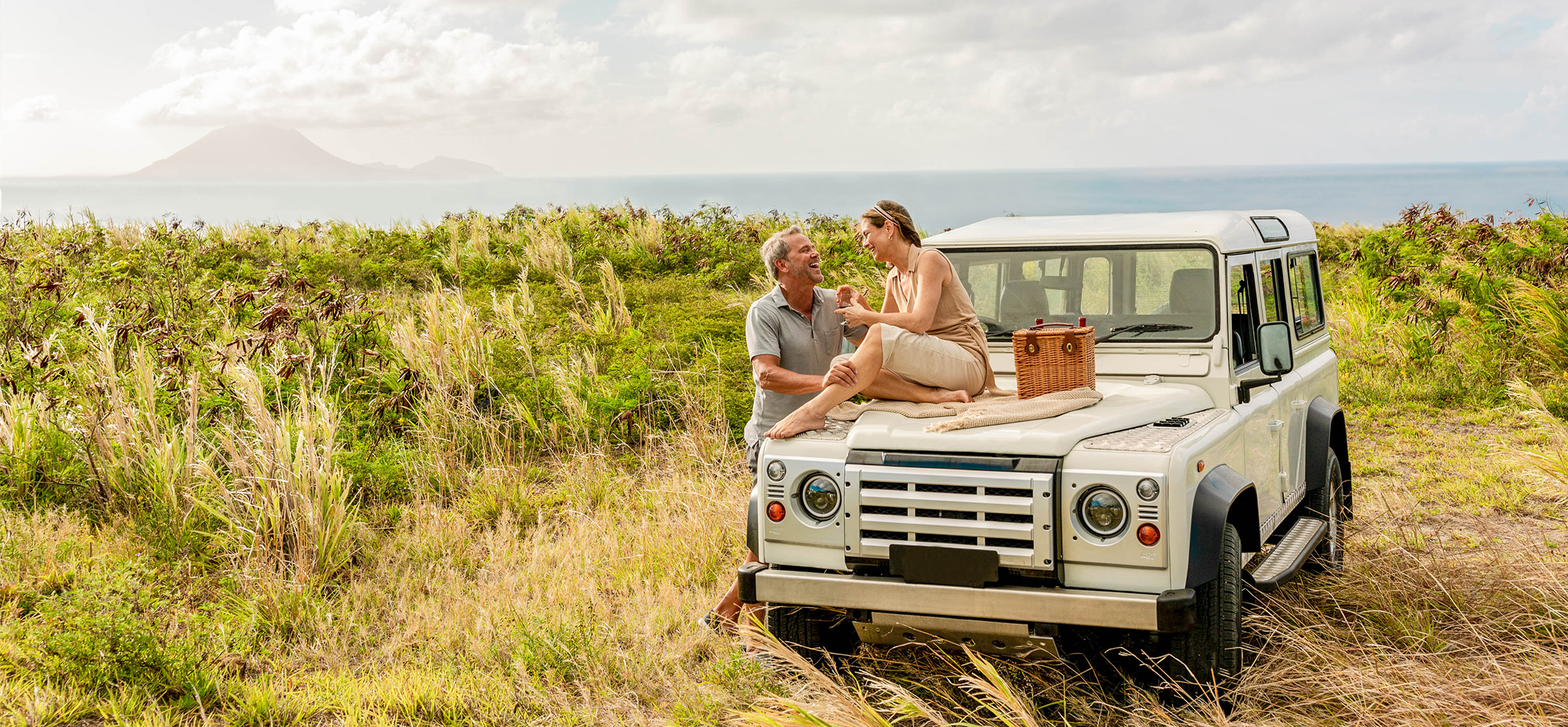 a man and woman sitting on a vehicle off road enjoying scenery