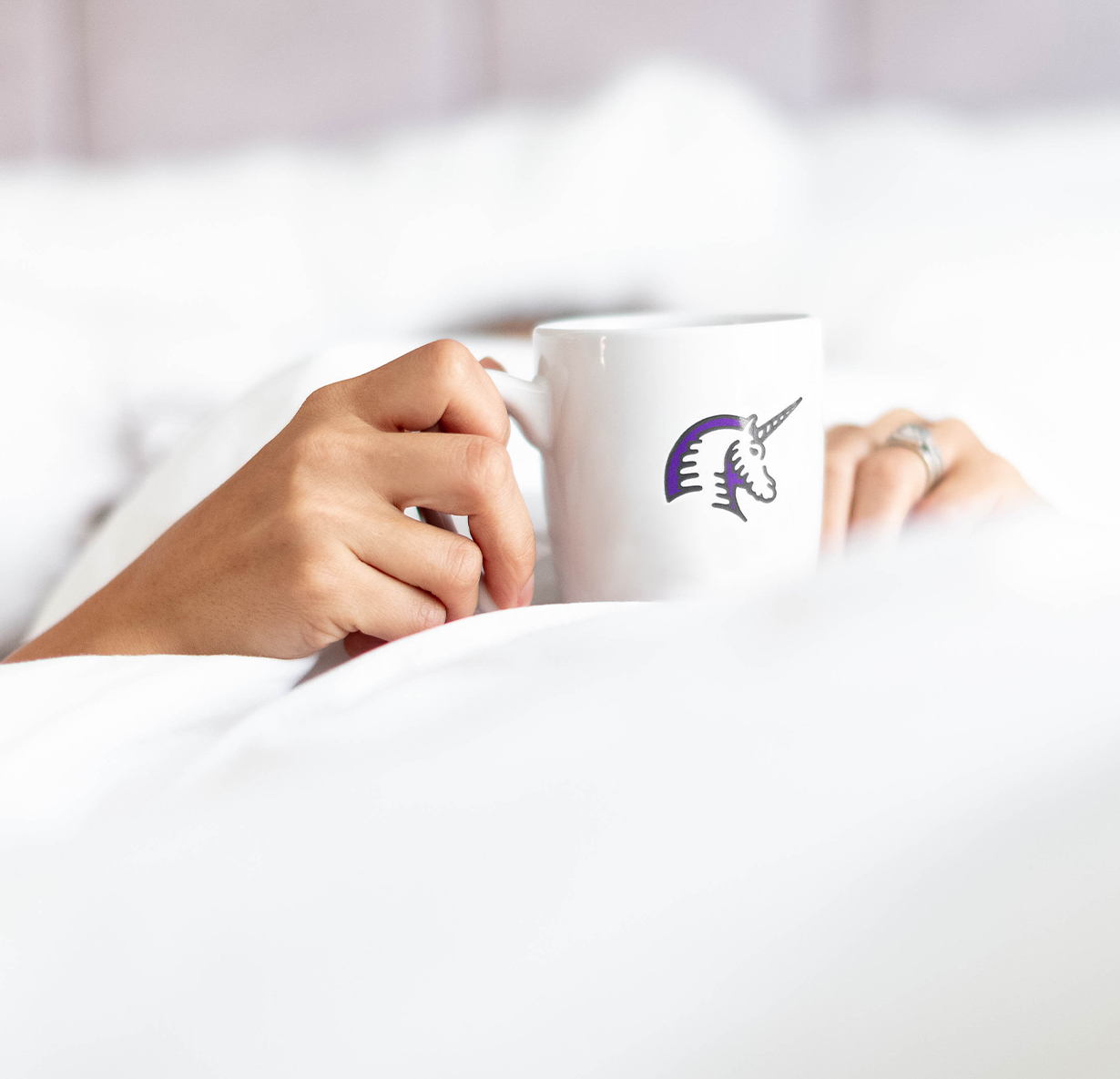 a person holding a white mug with the trundle logo on it