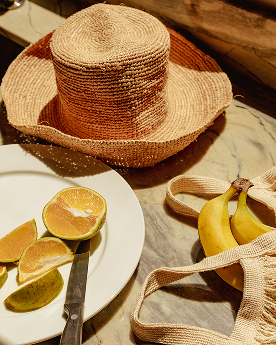 a straw hat and fruit on a plate