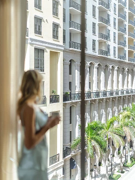 a woman standing in front of a window looking out a building
