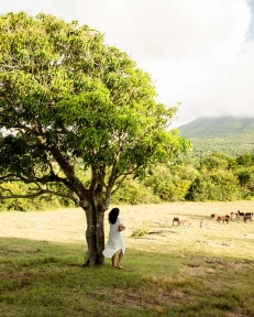 a woman standing next to a tree