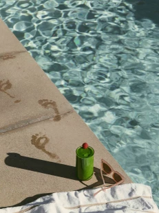 a pool with a green can and sunglasses