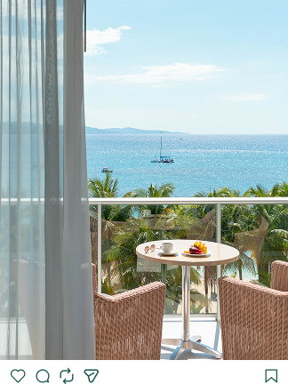 a table and chairs on a balcony overlooking the ocean