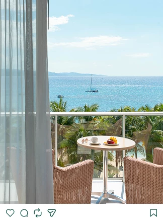 a table and chairs on a balcony overlooking the ocean