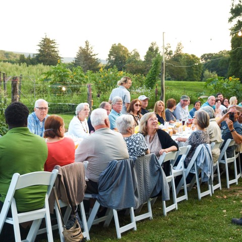 a group of people sitting at tables outside