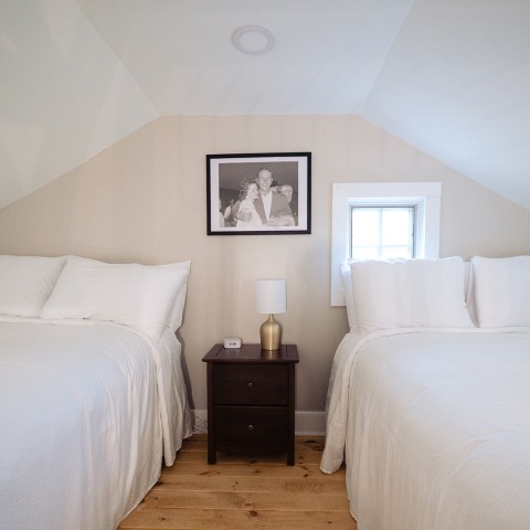 a room with two beds and a picture on the wall