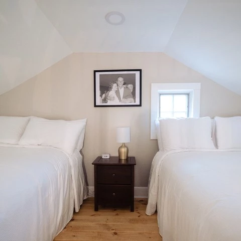 a room with two beds and a picture on the wall