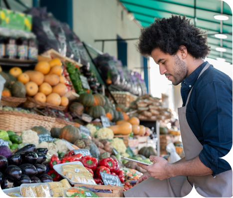 a man standing in front of a fruit stand
