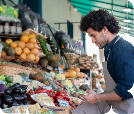 a man standing in front of a fruit stand