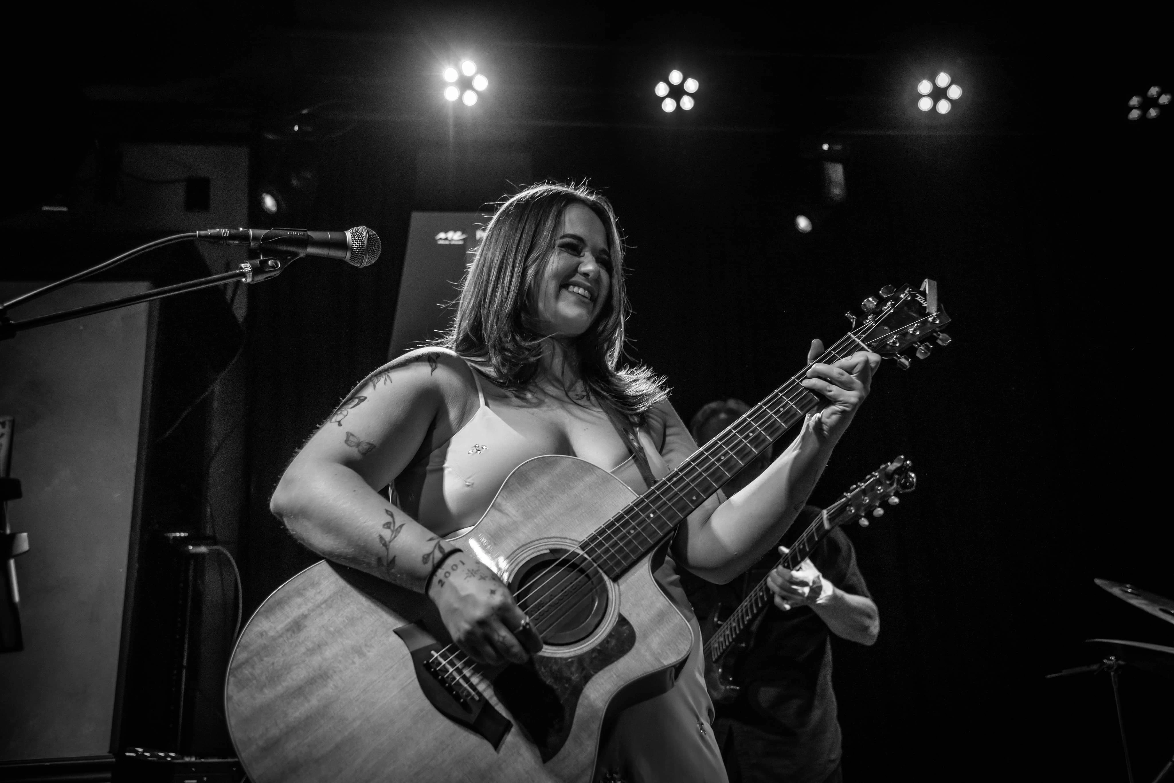 Hannah Noel playing guitar and singing