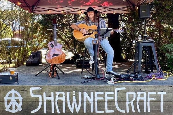 a man sitting on a stage playing guitar