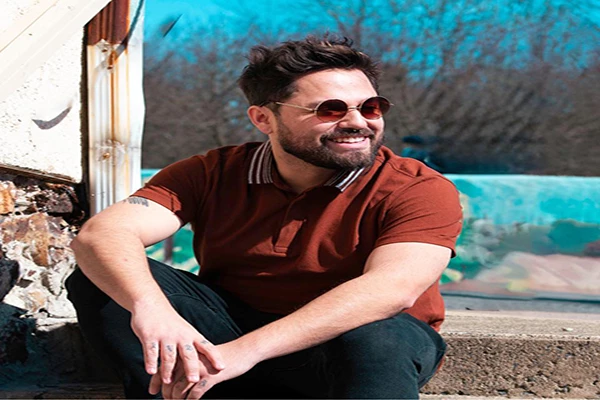 Performer, Sol Katana sitting on steps wearing sunglasses