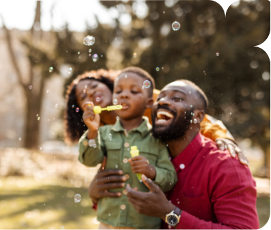 a man and woman with a child blowing bubbles
