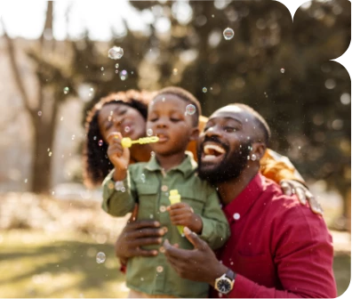 a man and woman with a child blowing bubbles